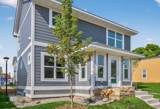 exterior of two story home with a small tree in the front yard